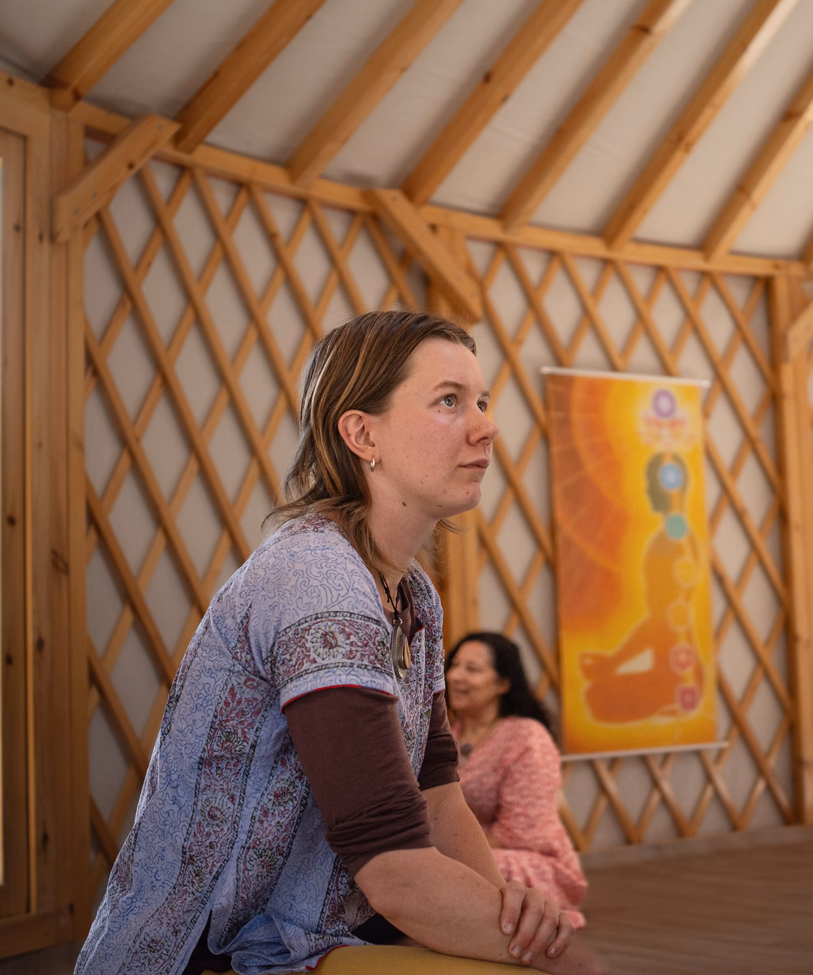 Mia Ruby Harrison listening attentively in a wooden yurt